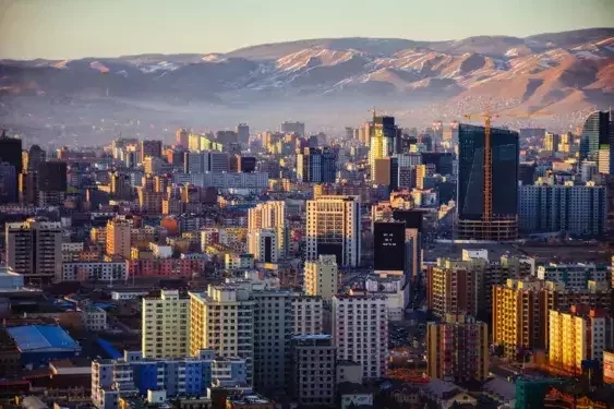 Ulaanbaatar city skyline in Mongolia featuring urban development set against snow-touched mountain ranges.