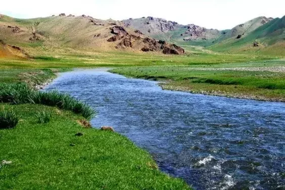 River running through a green valley in Mongolia.