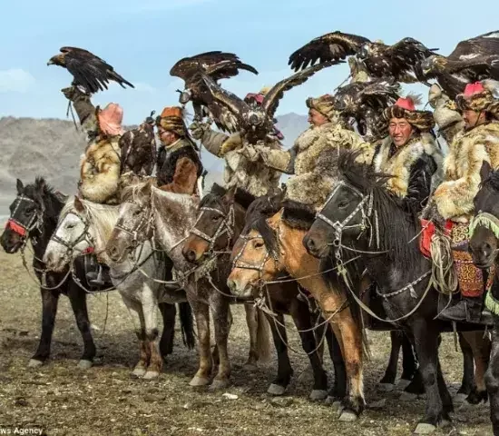 Mongolian hunters on horseback hunting with eagles