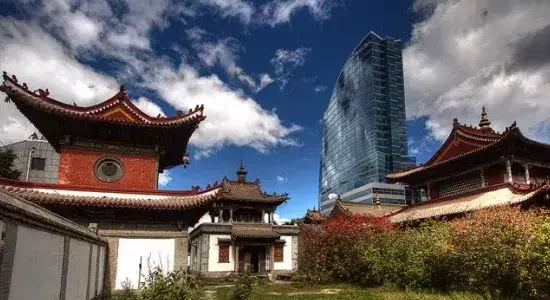 Temple buildings in Ulaanbaatar with a modern skyscraper in the background.