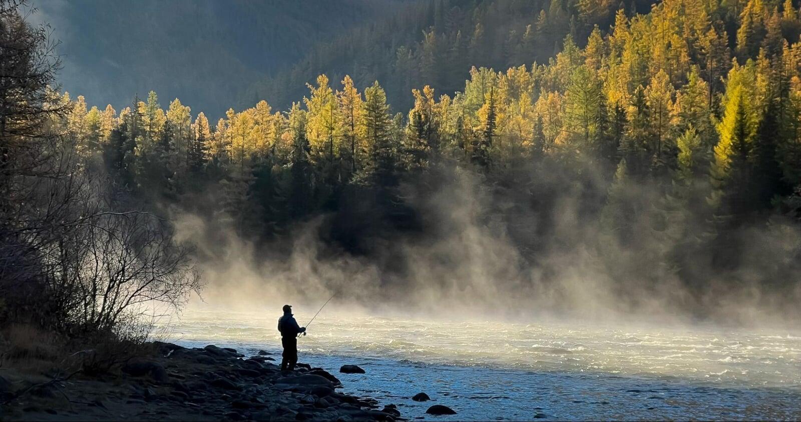 Khentii Mountains fly fishing scene on a misty river at sunrise in Mongolia’s remote wilderness